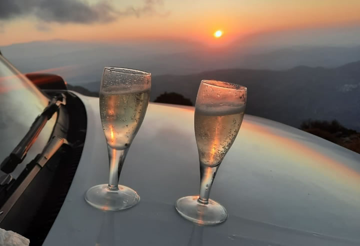 Open-top jeep driving through Cretan landscape at sunset